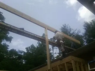 Carpenter setting a ridge beam over a new addition frame — Ice Dam Removal by Roofing Brothers in Prophetstown