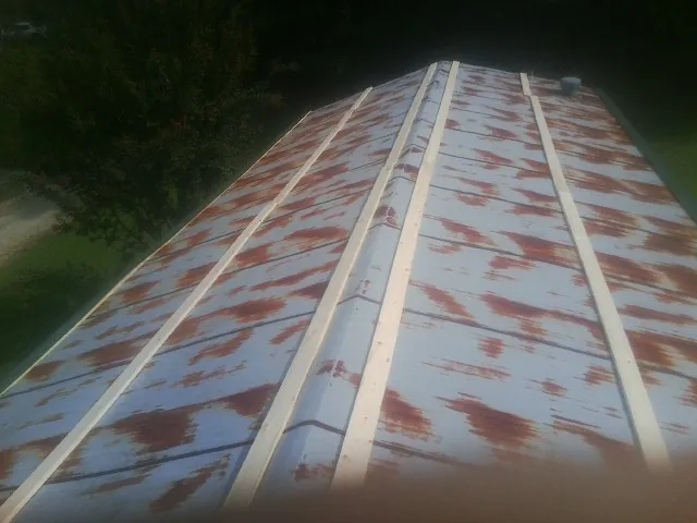 Rusted metal roof panels with new wood purlins before replacement — Storm Damage Roof Repair in Prophetstown by Roofing Brothers