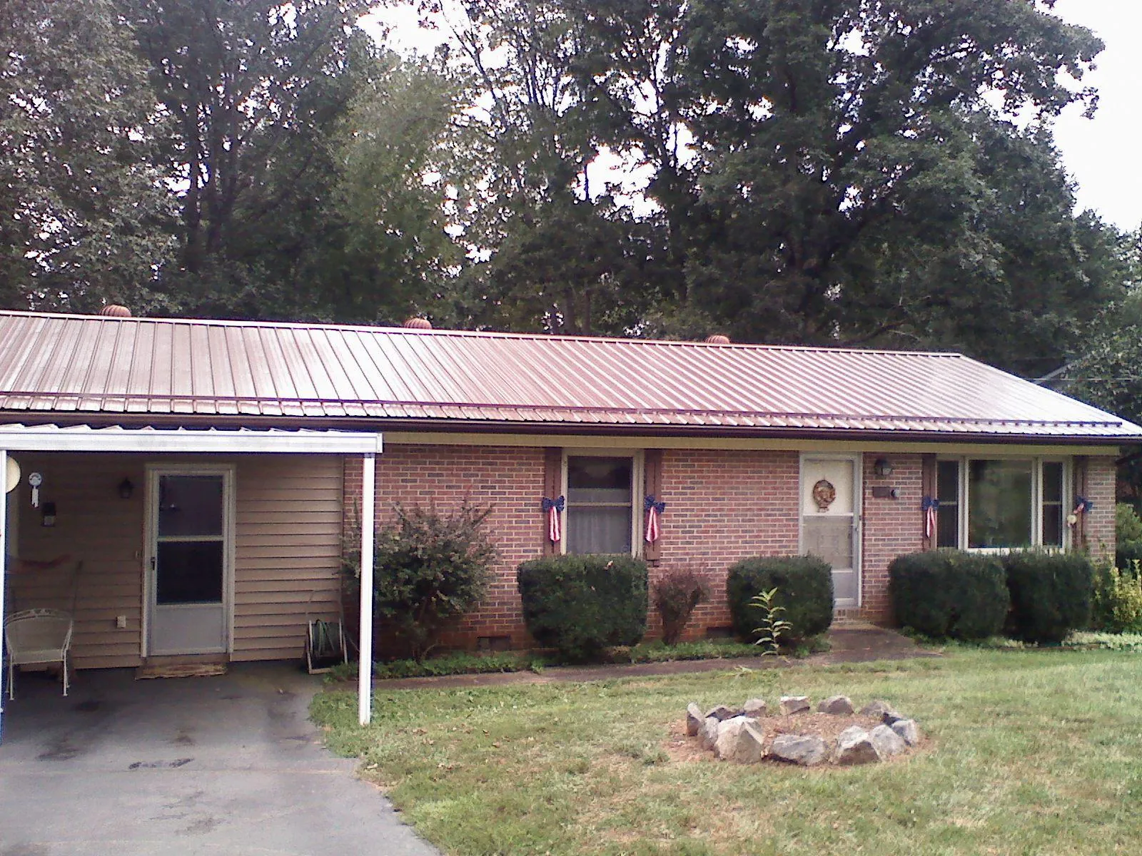 Bronze metal roof and carport on a brick ranch home — Roof Repair work by our crew in Prophetstown