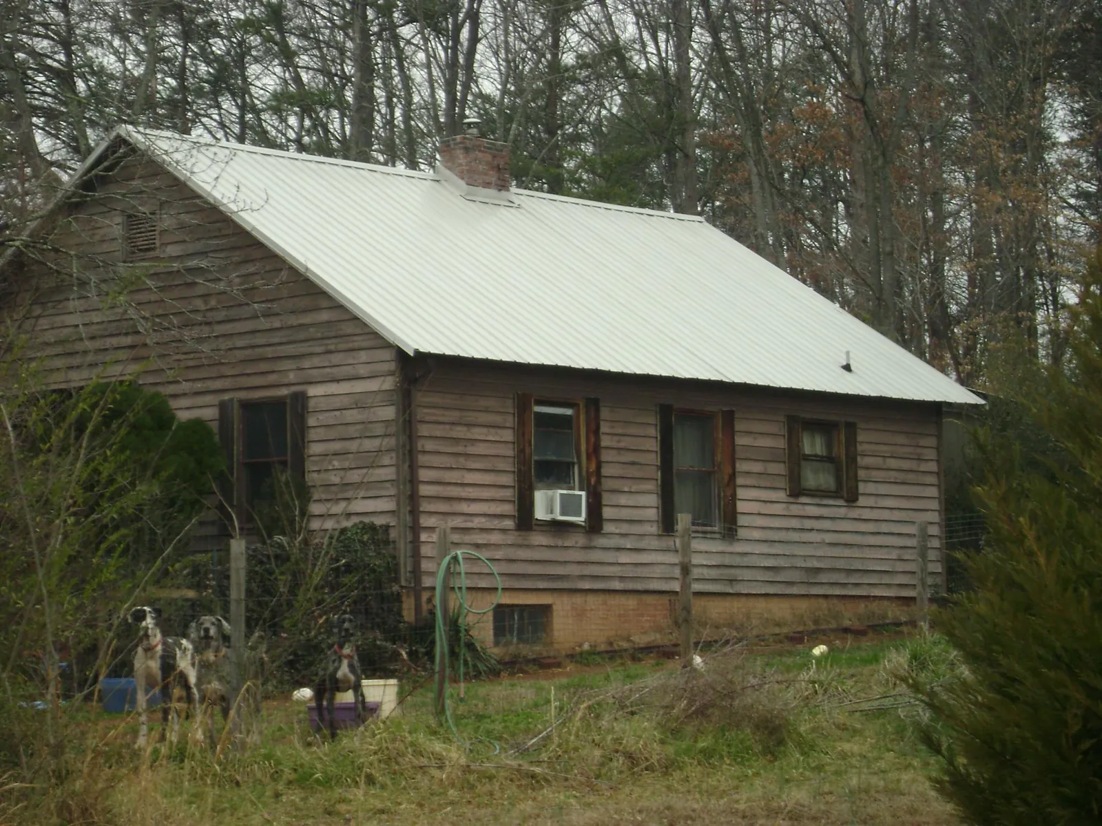 White metal roof on an old wood sided farmhouse, from a Metal Roof Installation job in Prophetstown